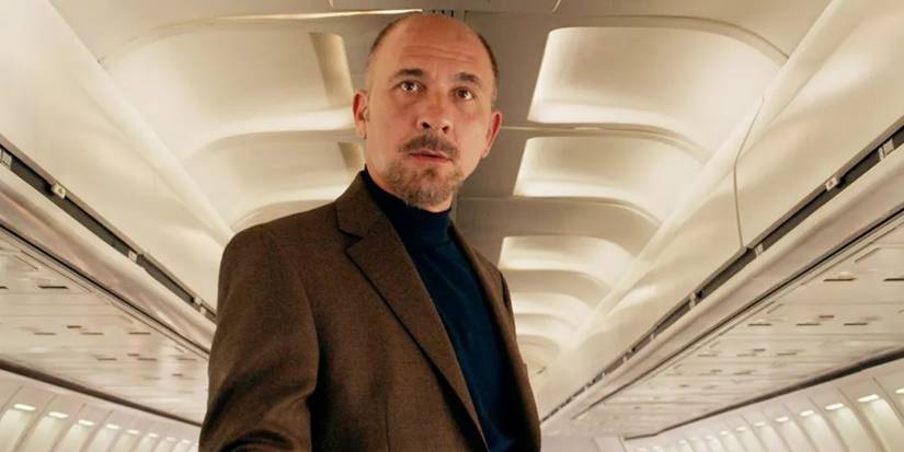Dario Grandinetti stands on the aisle inside an airplane in Wild Tales