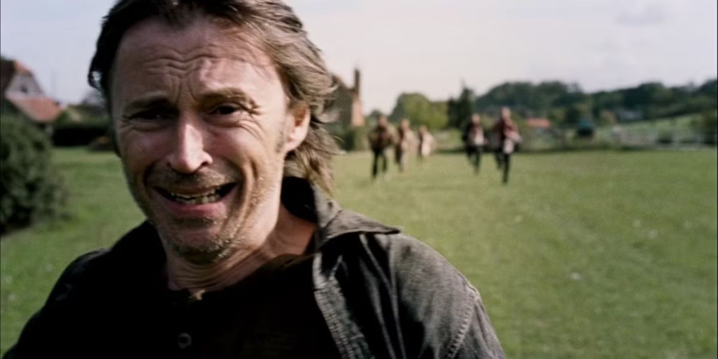 Robert Carlyle running away and looking scared with other figures behind him in 28 Weeks Later.