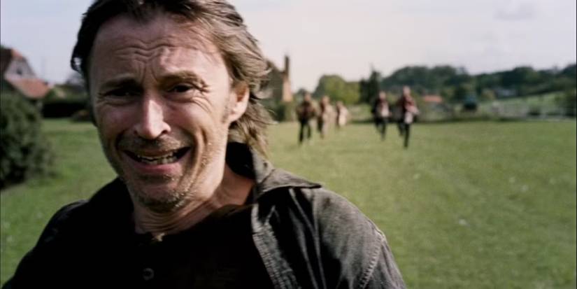 Robert Carlyle running away and looking scared with other figures behind him in 28 Weeks Later.