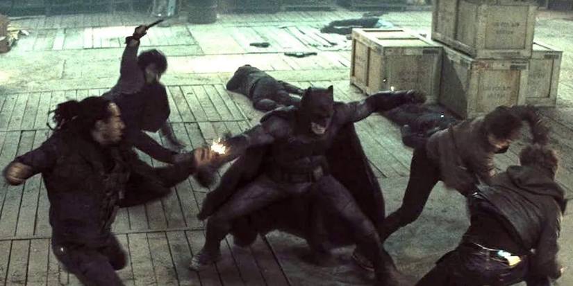 Batman melawan banyak pria bersenjata di gudang di Batman v Superman: Dawn of Justice.