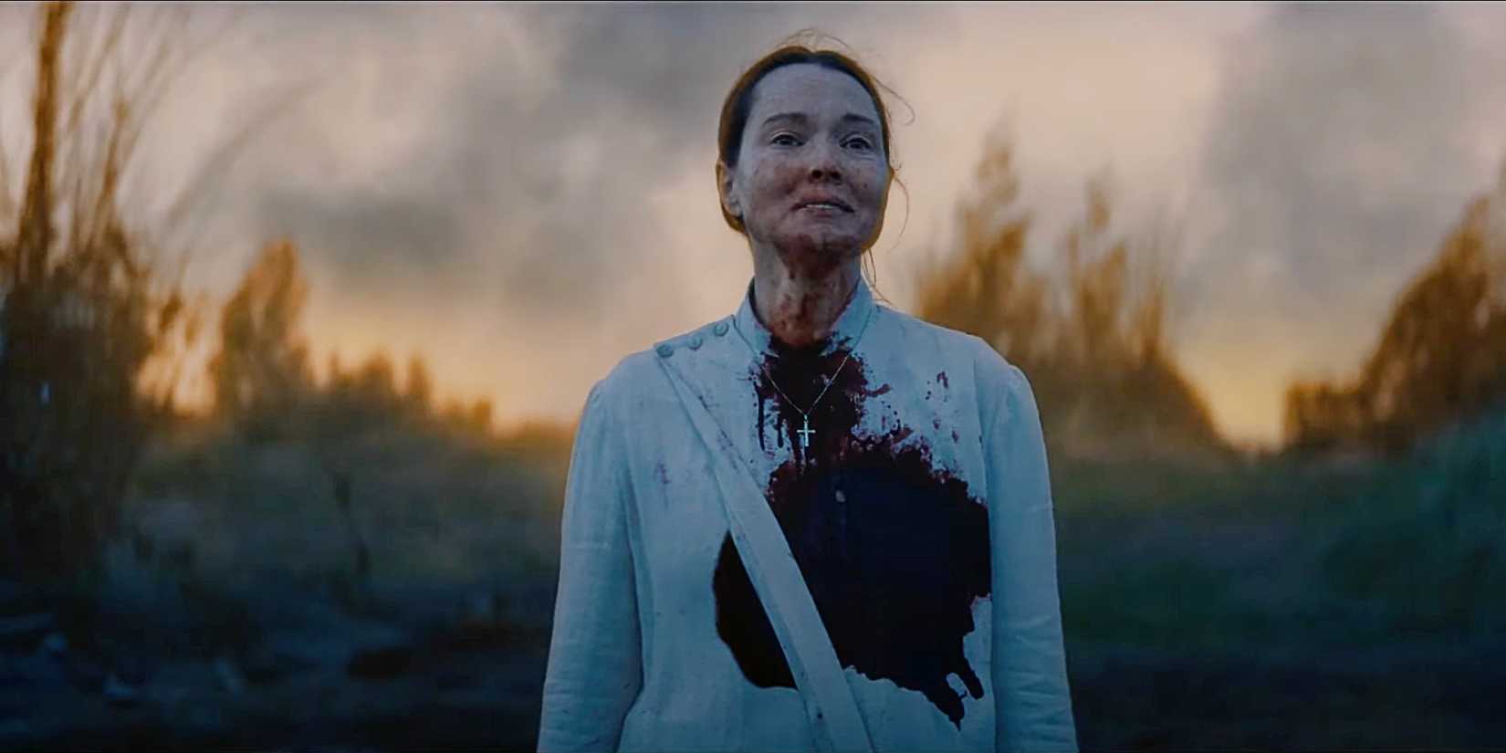Samantha Sloyan as Bev Keane covered in blood and standing outside just before the sunrise in Midnight Mass