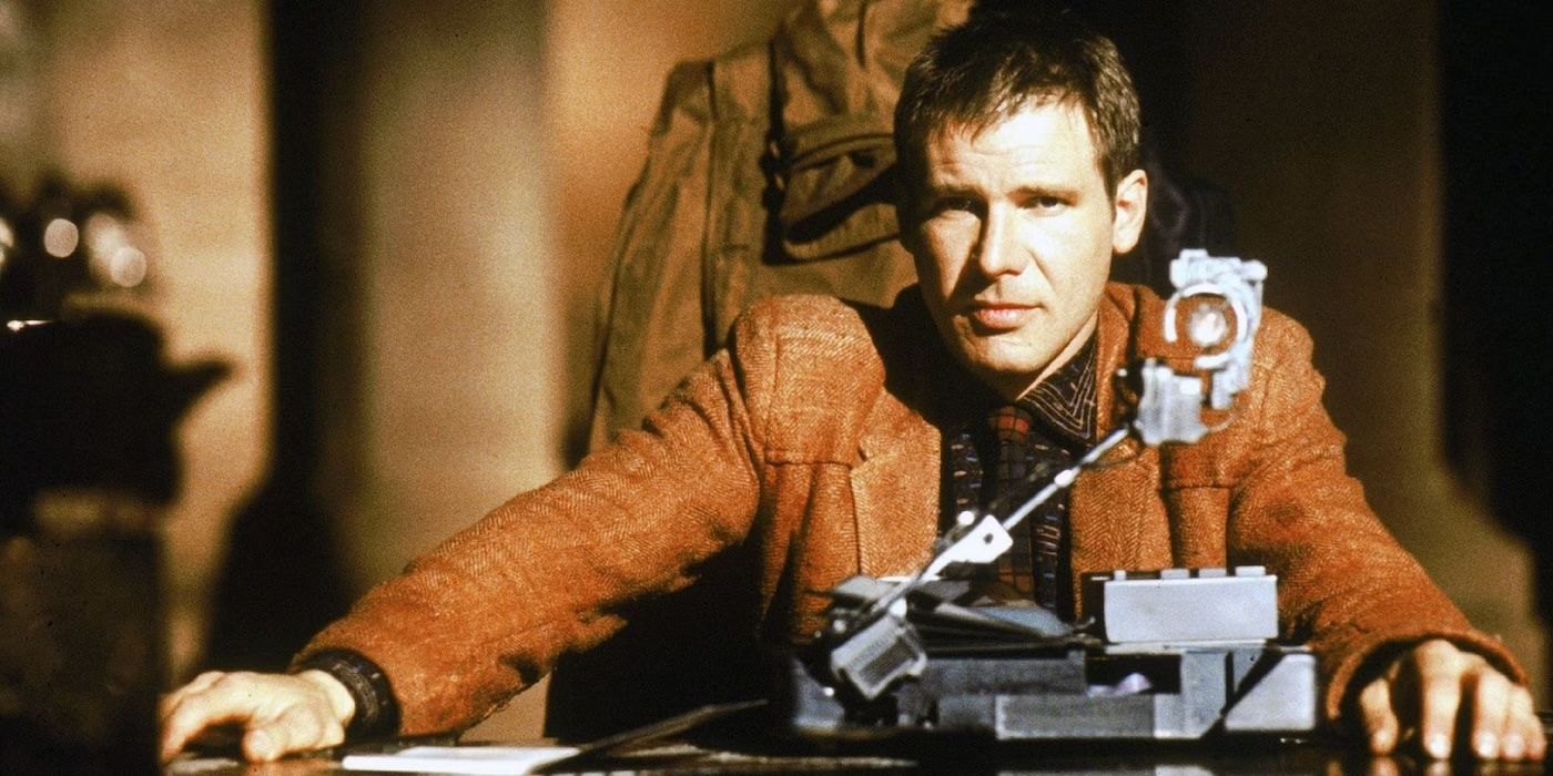 Harrison Ford sitting at a desk and looking ahead in Blade Runner, 1982. 
