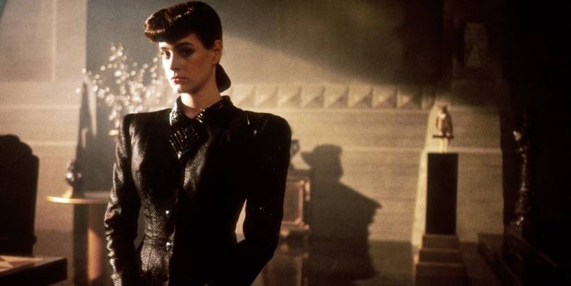 Sean Young as Rachael standing in a room with dramatic lighting and shadows in 'Blade Runner' (1982).