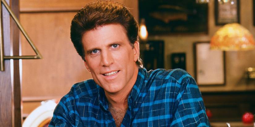 Ted Danson as Sam Malone standing behind the bar on Cheers.