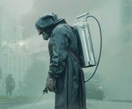 Person in a radioactive suit spraying a chemical in a foggy background in 'Chernobyl.'
