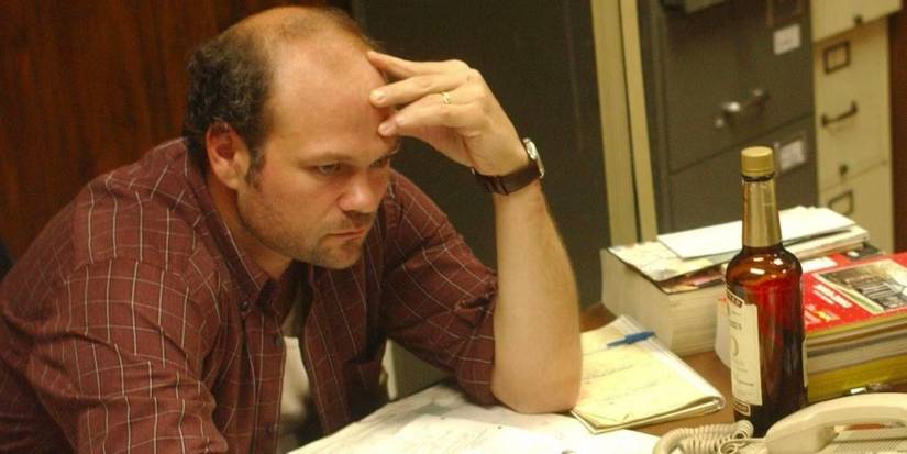 Chris Bauer as Frank Sobotka sits at his desk with a bottle of alcohol in The Wire episode Bad Dreams.