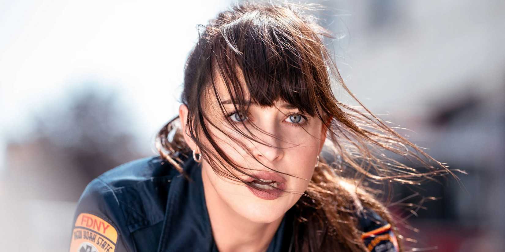 Dakota Johnson looks up at a car crash in Madame Web