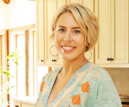 Promotional image of Erin Napier smiling in a warmly lit kitchen