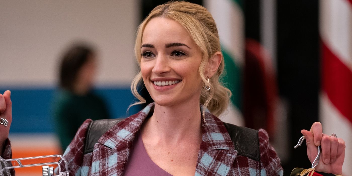Brianne Howey's Georgia smiling while holding up clothes on hangers in Ginny & Georgia Season 2.