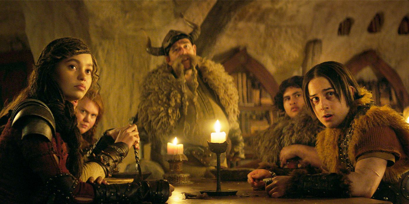 Gobber and the young vikings sitting around a table in the Great Hall 