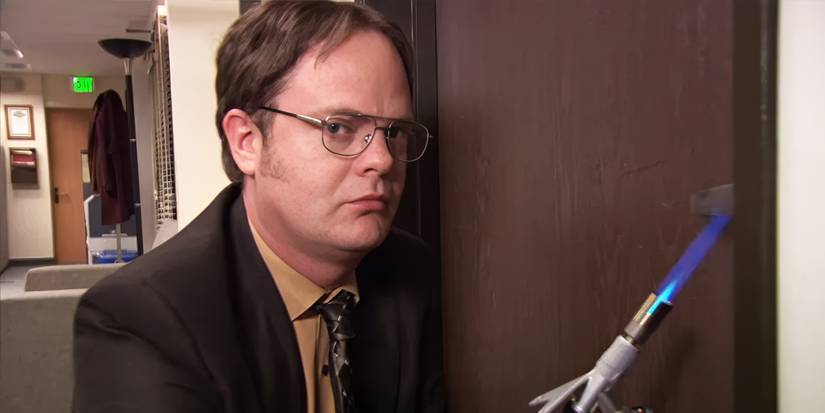 Dwight (Rainn Wilson) holding a blowtorch to the door knob in The Office