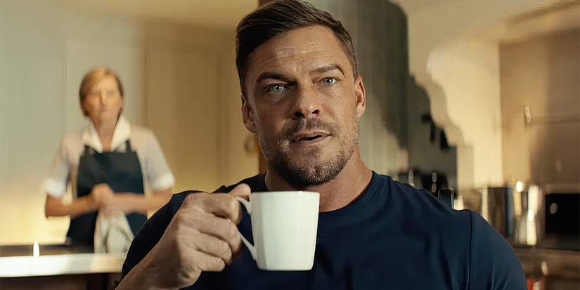 Alan Ritchson's Reacher holding a mug.
