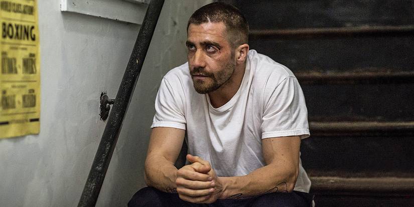 Jake Gyllenhaal as Billy Hope sitting on stairs looking serious in Southpaw.