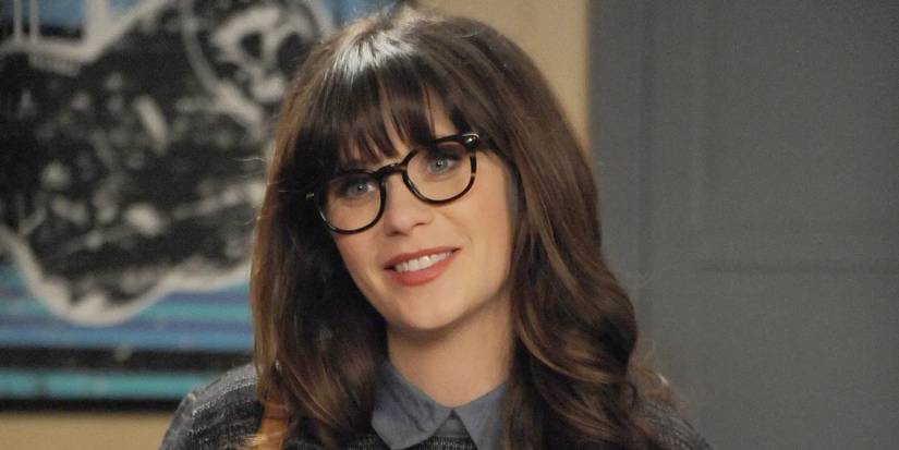 Zooey Deschanel as Jess Day wearing glasses and smiling in New Girl.
