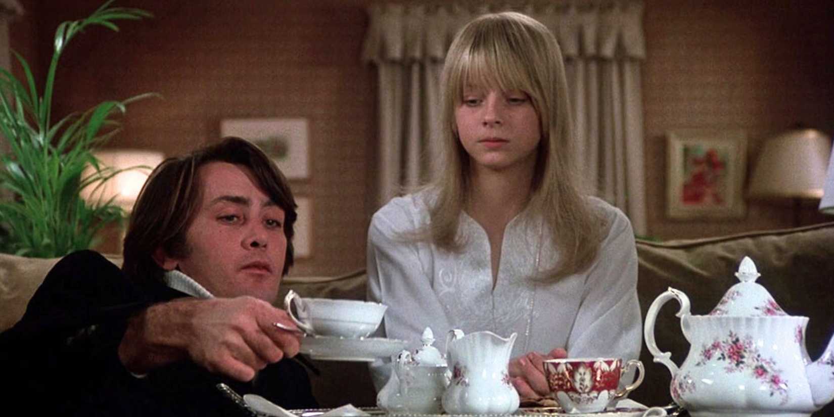 Jodie Foster sitting next to Martin Sheen who is holding a cup of tea in The Little Girl Who Lives Down the Lane (1976)