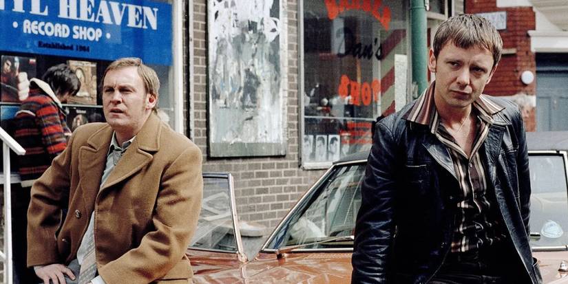 Sam Tyler and Gene Hunt outside and leaning against a car in Life on Mars.