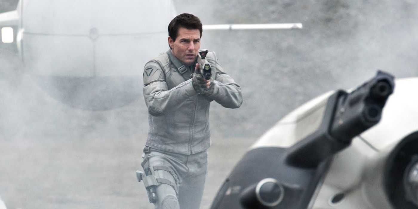 Tom Cruise aiming a futuristic rifle in a white futuristic uniform in Oblivion.