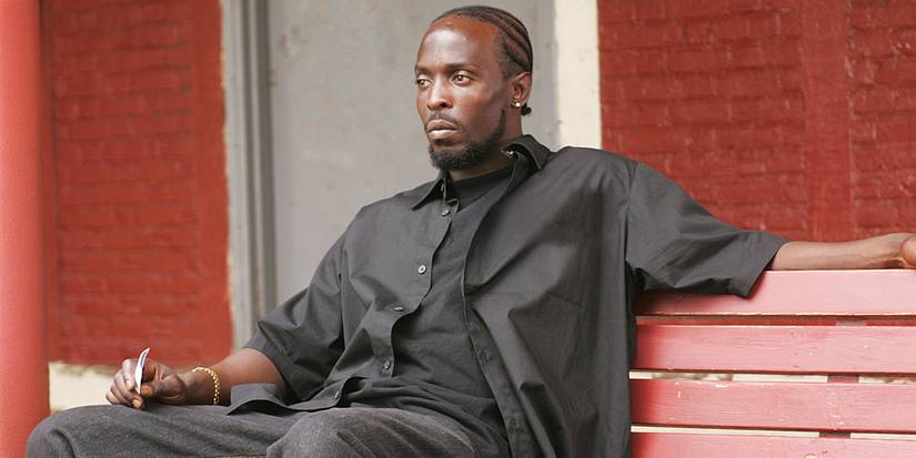 Michael K. Williams as Omar Little sitting on a bench and staring ahead in The Wire.