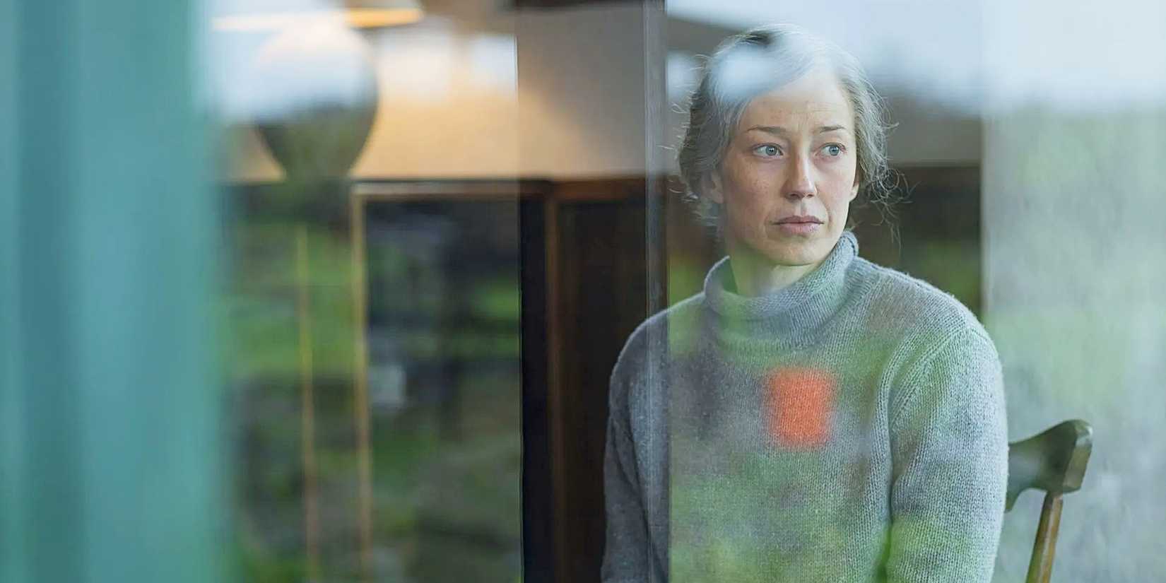 Carrie Coon as older Nora Durst staring out a window in the series finale of The Leftovers