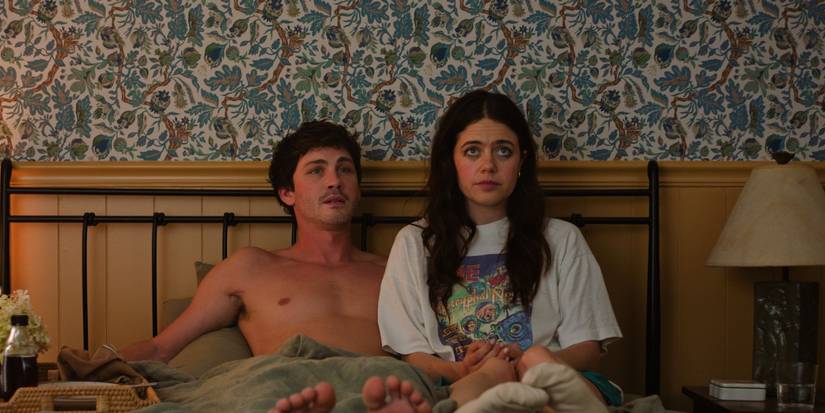Image from 'Oh, Hi!' shows a shirtless Logan Lerman and Molly Gordon sitting side by side on a bed.