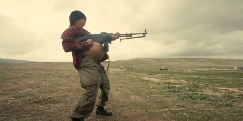 Perfidia Beverly Hills pregnant and screaming while firing a gun in One Battle After Another