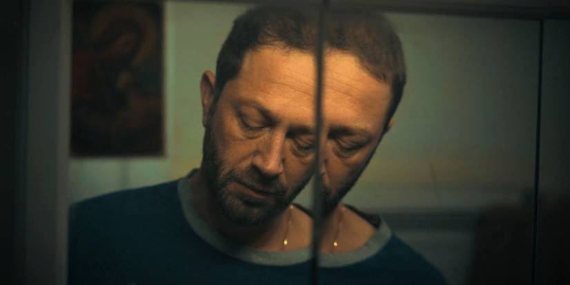 Richie (Ebon Moss-Bachrach) has a pained expression, his reflection split in a layered mirror in The Bear.