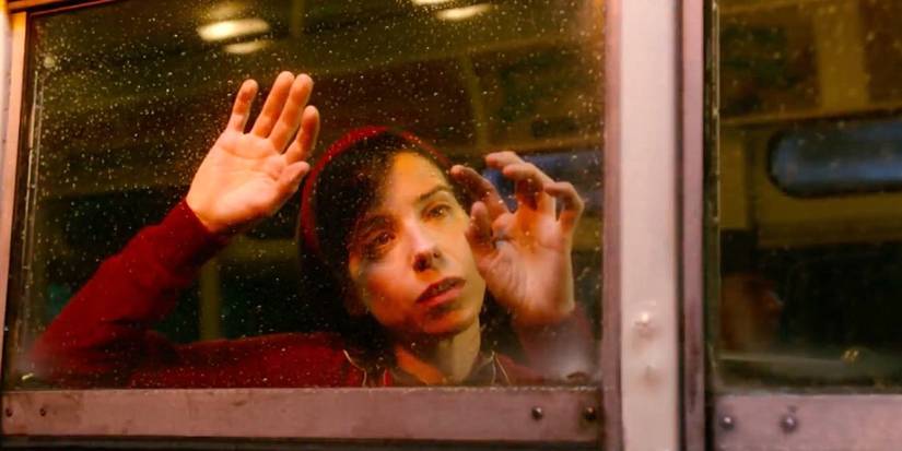 Elisa (Sally Hawkins) touches a rain-streaked bus window in The Shape of Water.
