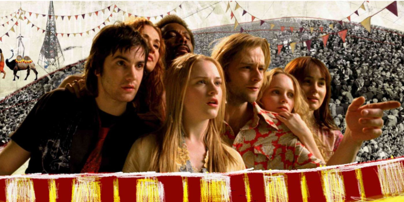 Jim Sturgess, Evan Rachel Wood, and Joe Anderson as Jude, Lucy, and Max standing in front of a circus staring and pointing in 'Across the Universe'
