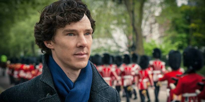 Benedict Cumberbatch sebagai Sherlock Holmes di Sherlock, berdiri di sebuah taman dengan anggota penjaga kerajaan di belakangnya.