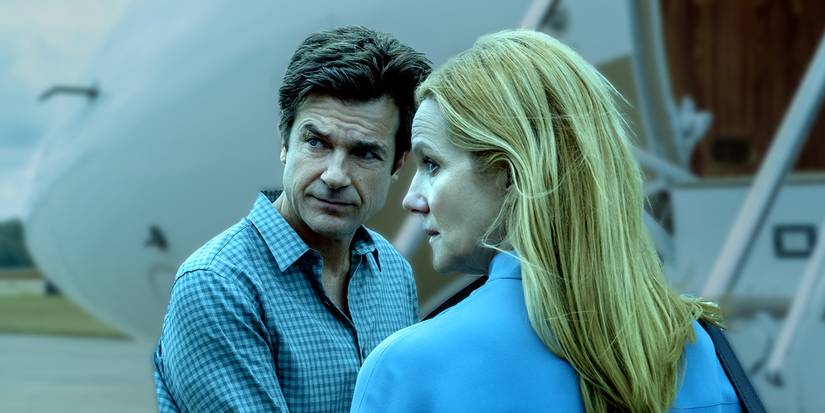 Seorang pria dan wanita melihat ke belakang mereka dengan ekspresi serius di Ozark.