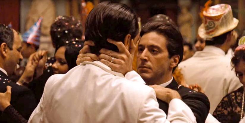 Michael Corleone holds Fredo by the face at a party and stares at him intently in The Godfather Part II, 1974