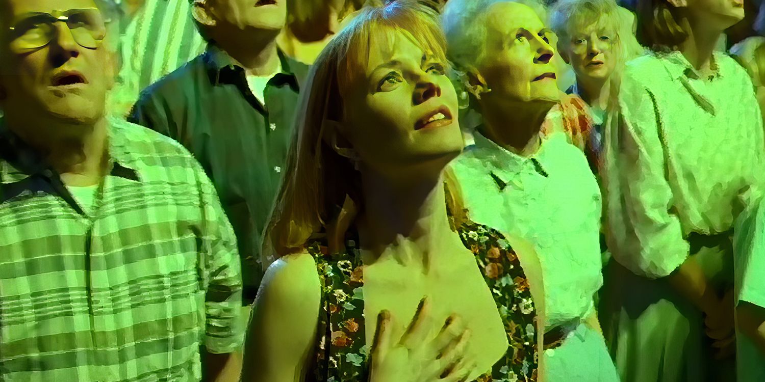 Bobbi, played by Marg Helgenberger, stands at the front of a dazed crowd looking up into a green light in The Tommyknockers.