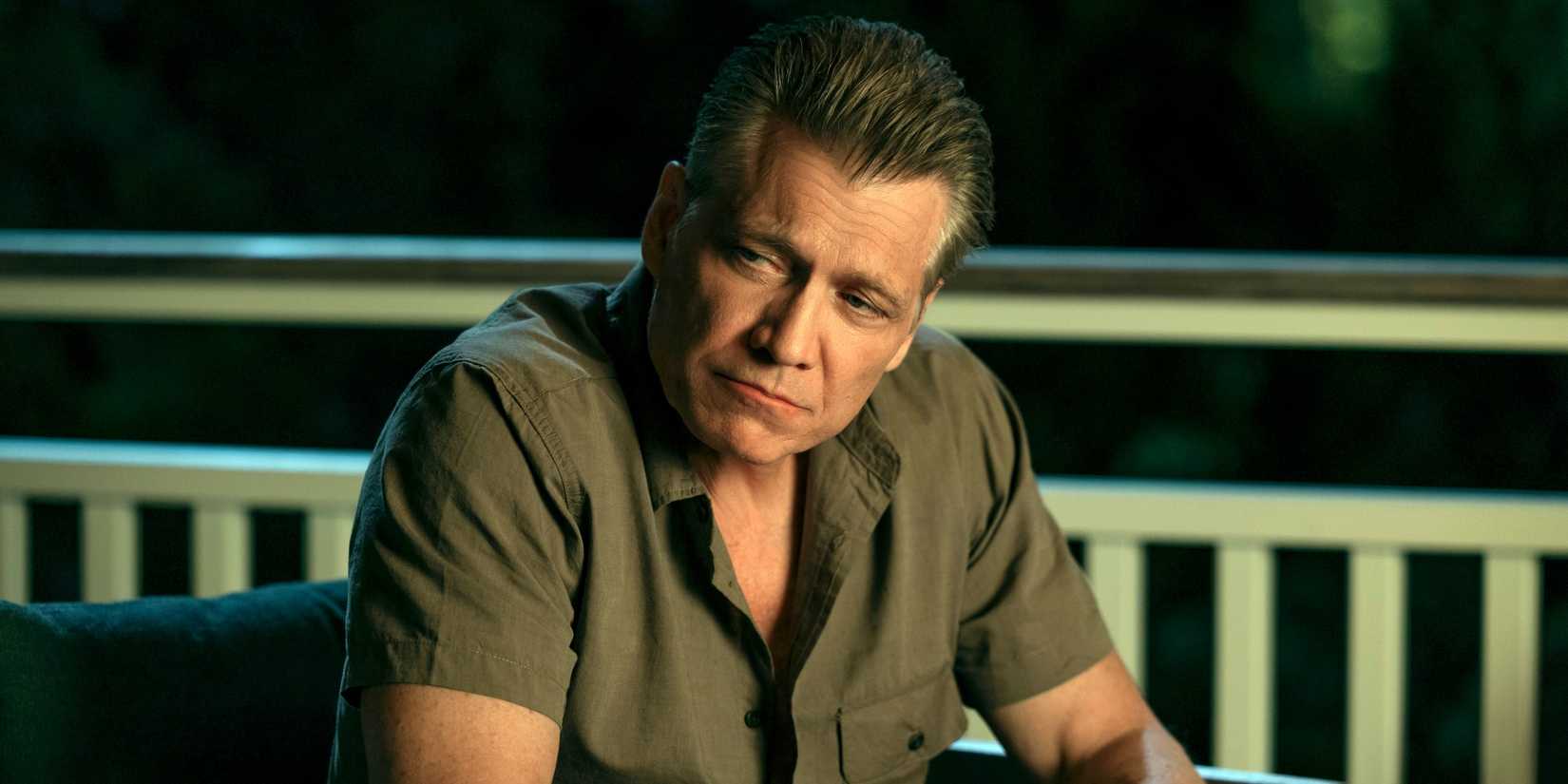 Holt McCallany as Harlan Buckley sitting outside while looking to the right in The Waterfront