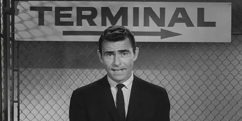 Rod Serling stands in front of a wire fence and "terminal" sign in Twilight Zone's Nightmare at 20,000 Feet.