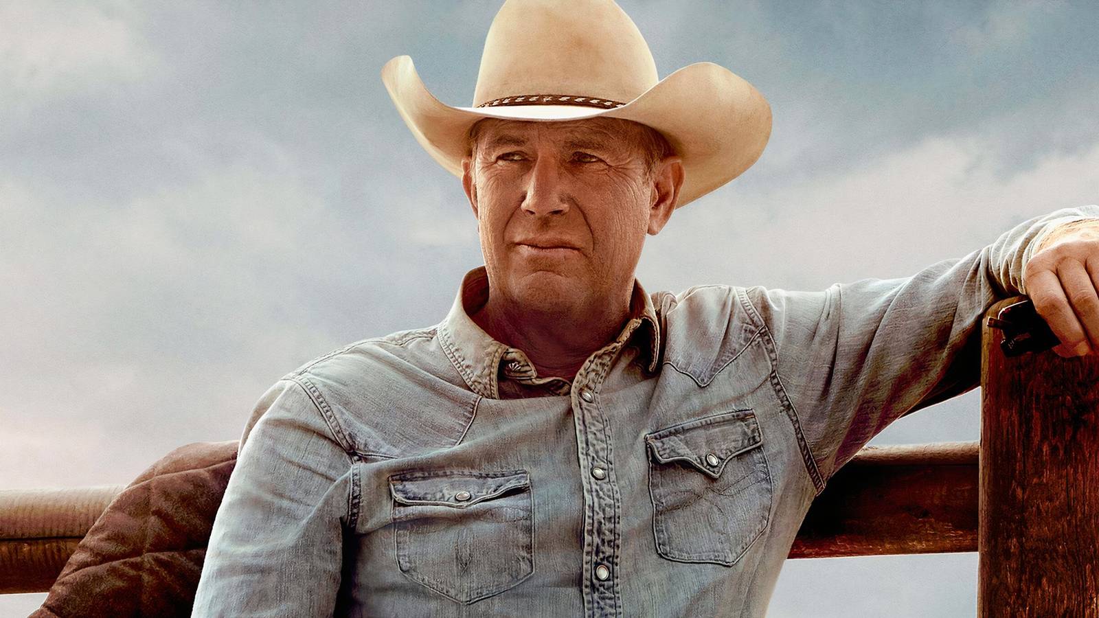 Kevin Costner leaning against a fence in Yellowstone