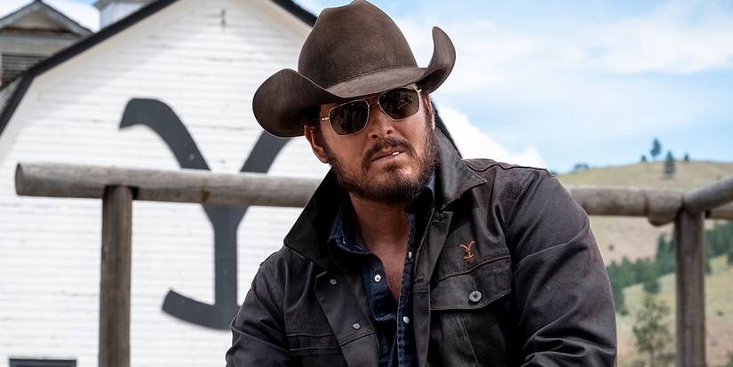 Cole Hauser as Rip Wheeler in sunglasses and a cowboy hat with a toothpick in his mouth in Yellowstone.