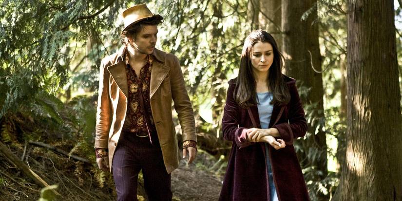 Andrew-Lee Potts as Hatter and Caterina Scorsone as Alice walk in the woods in 'Alice.'
