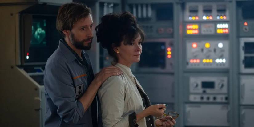 David Rysdahl and Essie Davis standing close together and looking to the side in Alien: Earth.