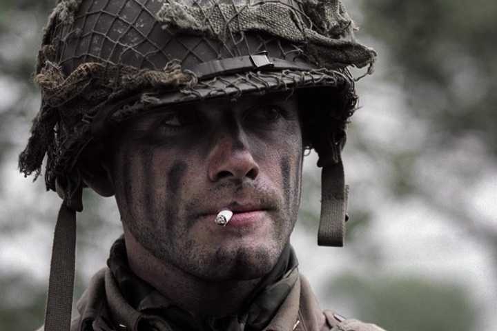 Matthew Settle with a cigarette in his mouth looking at someone off-screen to the right in Band of Brothers, Day of Days