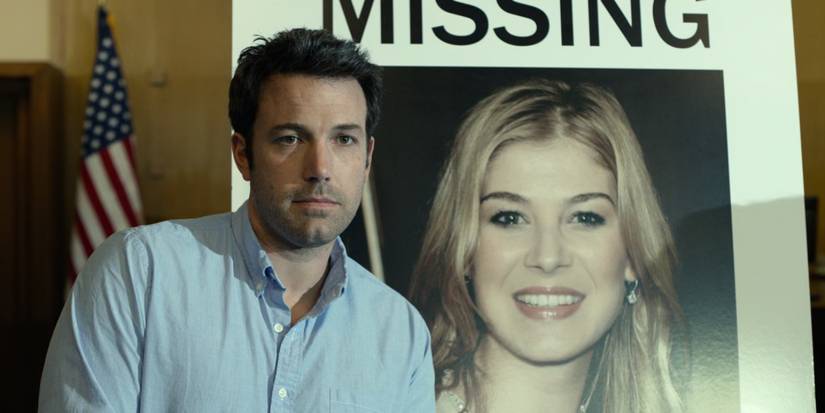 Nick Dunne, played by Ben Affleck, standing in front of a missing persons poster in Gone Girl
