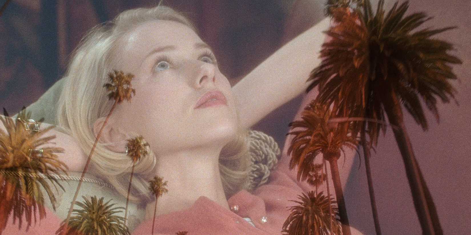 Betty (Naomi Watts) lays down and looks upward as the frame transitions between her face and palm trees in David Lynch's 'Mulholland Drive'