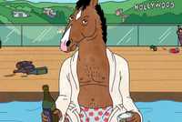 BoJack sits by a pool in a bathrobe holding a beer with the Hollywood sign behind in BoJack Horseman.