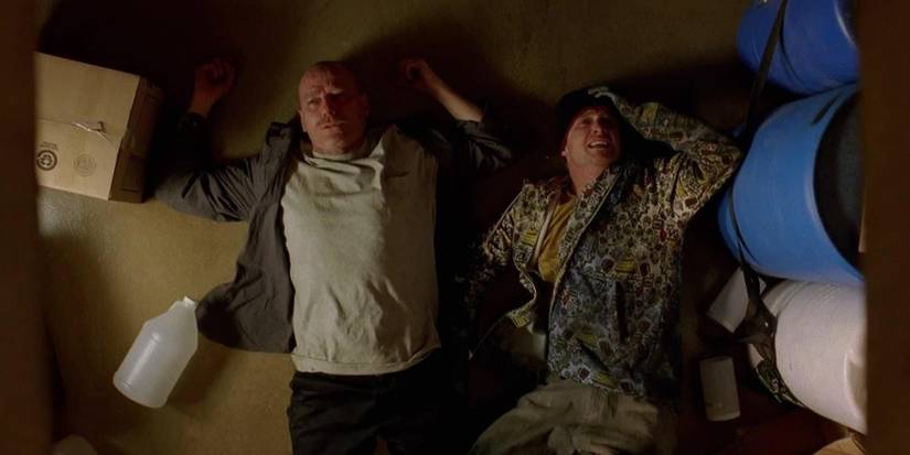 Bryan Cranston and Aaron Paul lying on a floor next to containers in 'Breaking Bad's episode "Down".