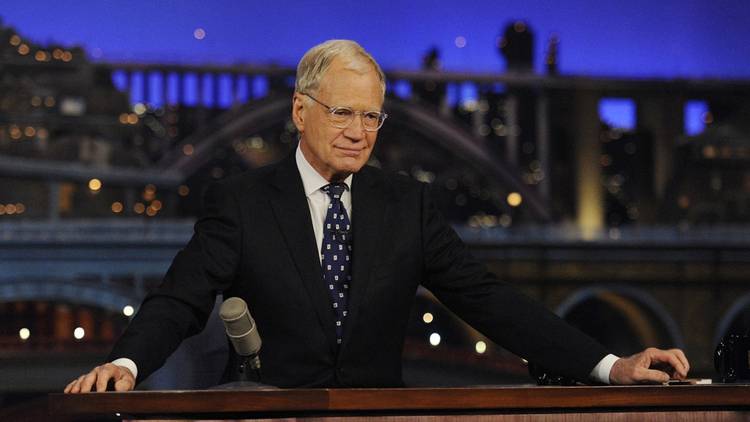 David Letterman behind his desk in Late Night with David Letterman.