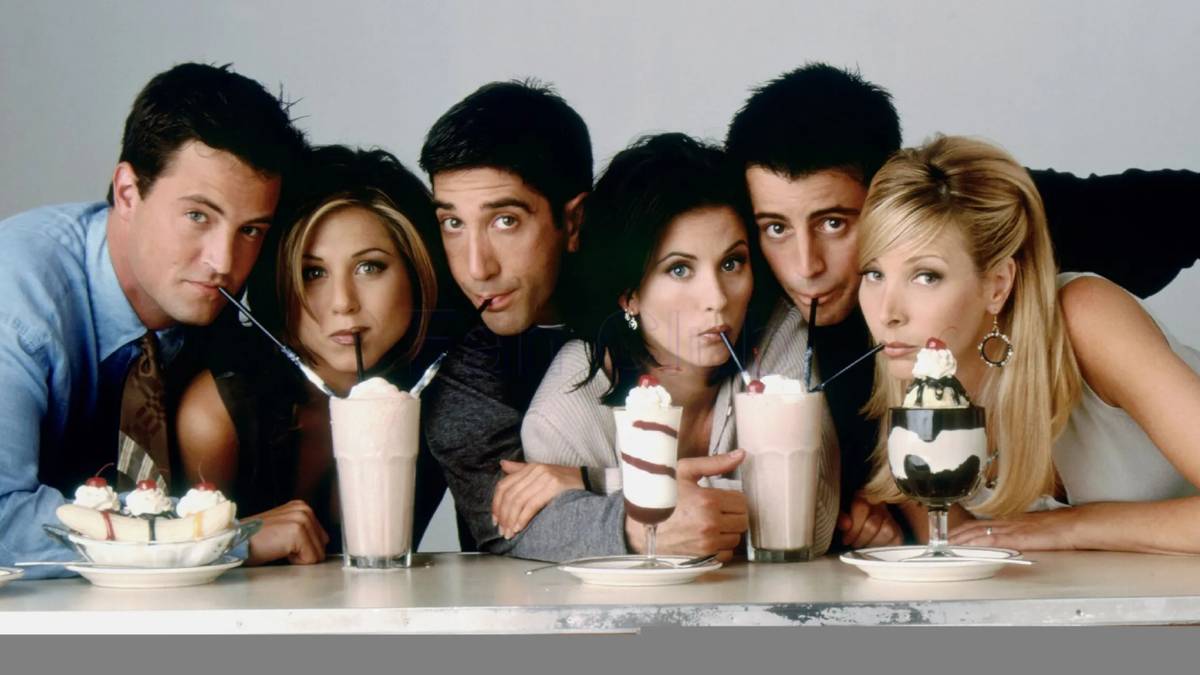 The cast of Friends drinking from straws in milkshakes while looking at the camera in a promo photo.
