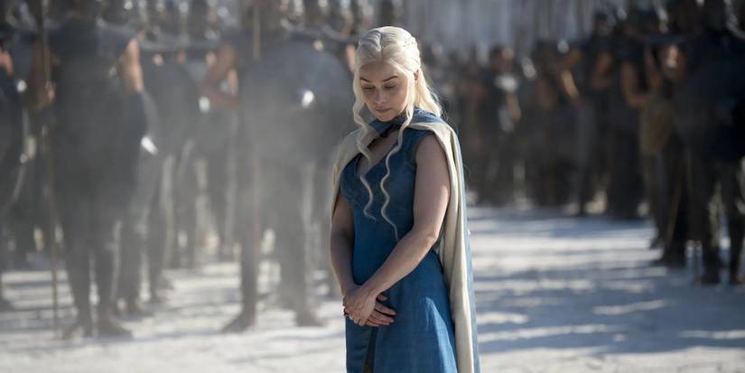 Emilia Clarke as Daenerys Targaryen in a blue dress in front of her army of the Unsullied in Game of Thrones.