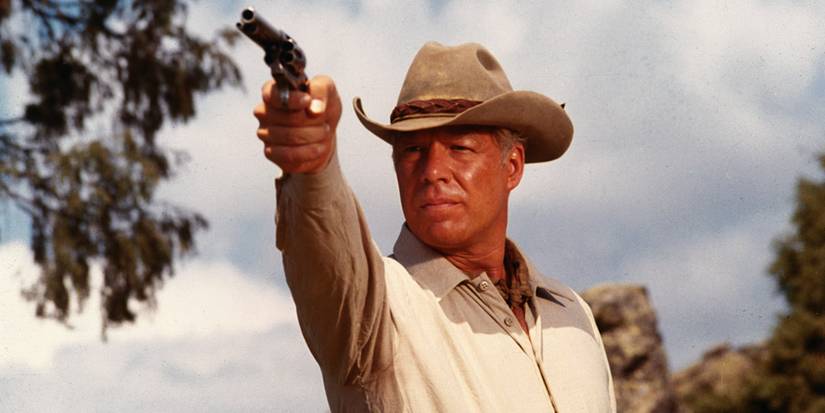 A man aiming a gun at the distance in Guns of the Magnificent Seven