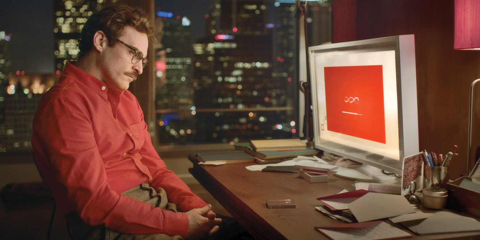 Joaquin Phoenix looking sad and contemplative in front of a computer screen in Her (2013)