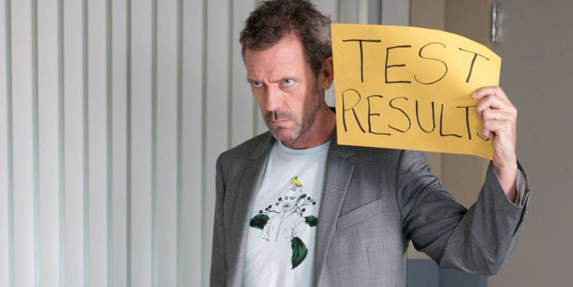 Hugh Laurie holds a handwritten sign that says "Test Results" in House M.D. Season 7, Episode 2, Selfish.