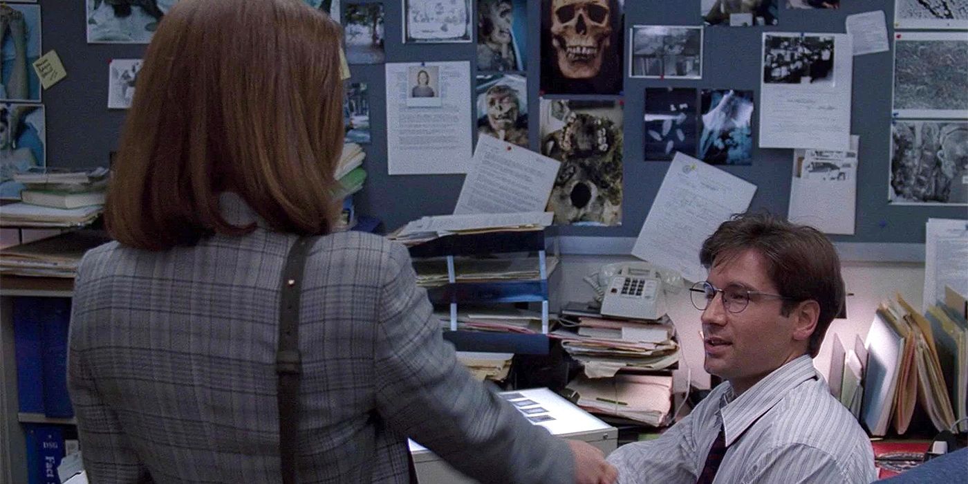 Mulder and Scully shake hands in Mulder's cluttered office in The X-Files' pilot.